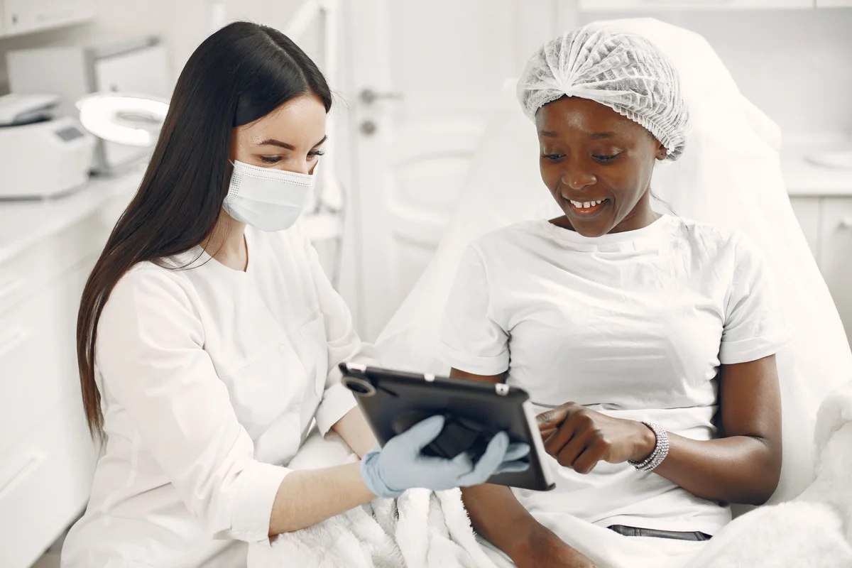A skin-care specialist and client reviewing information on a tablet during a consultation, not a treatment result