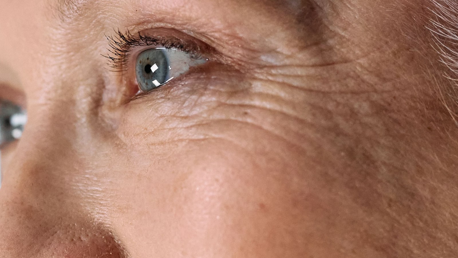 Close-up of the eye area showing fine lines at the outer corner and under the lower lid
