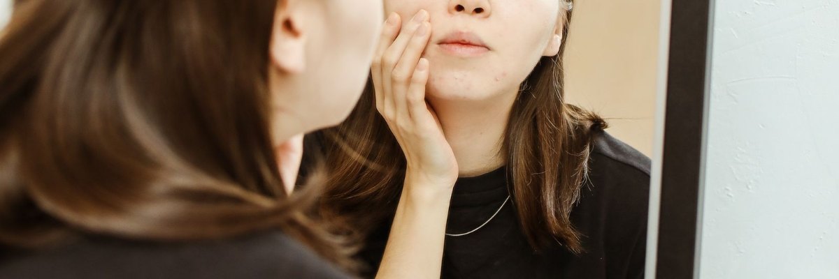 거울로 볼과 턱선을 살피는 모습